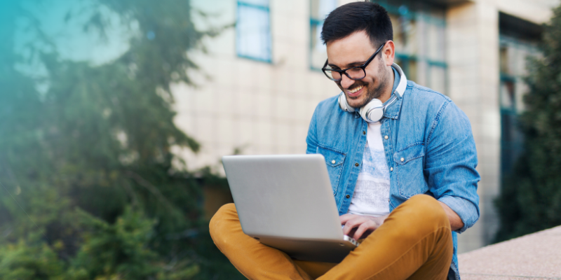 Freelancer oder Festangestellte - Mann arbeitet glücklich am Laptop 